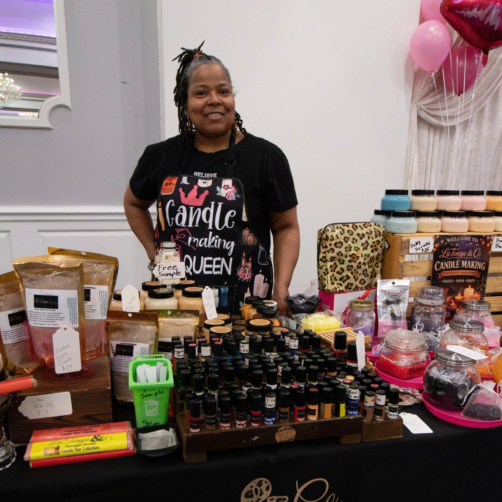 Woman standing behind a table displaying various products with 'La Tonya & Co' branding.